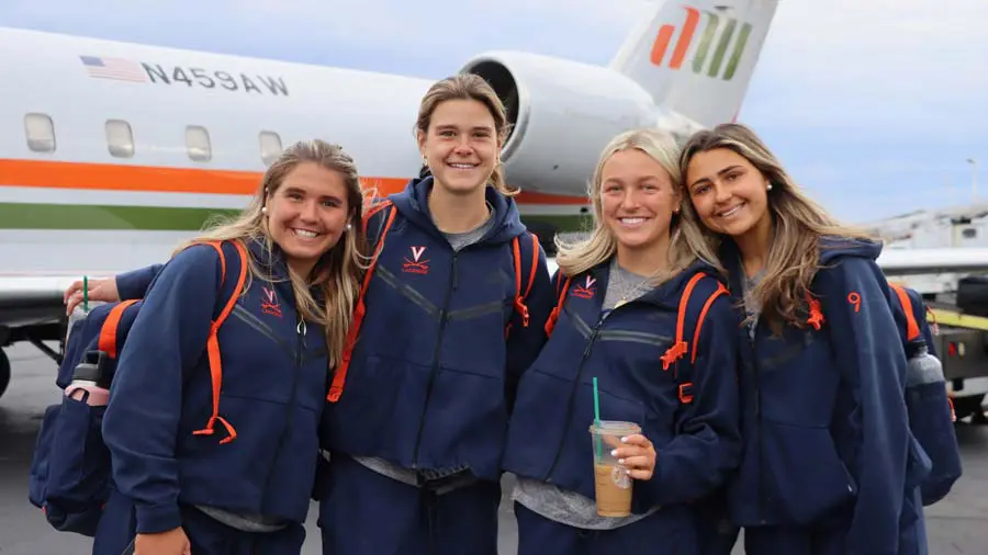 Women posing in front of plane smiling