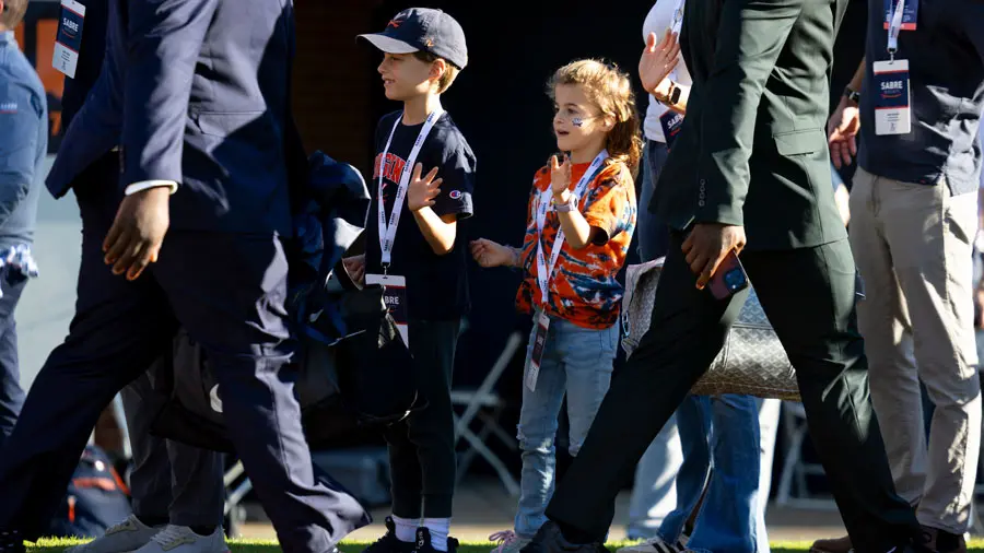 Sabre society members kids giving high fives to UVA football players on the field