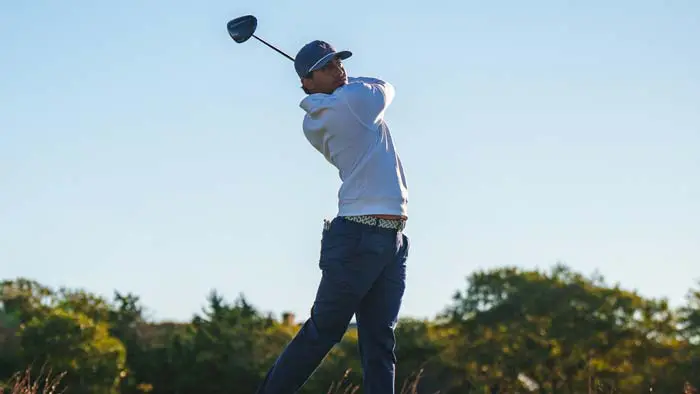Student-athlete swinging golf club