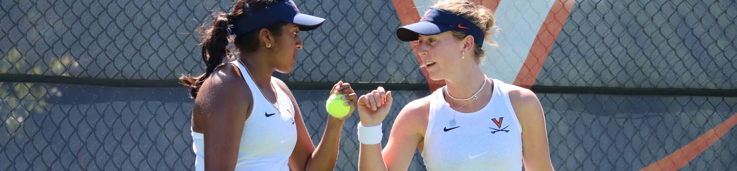 Two tennis players fist bumping
