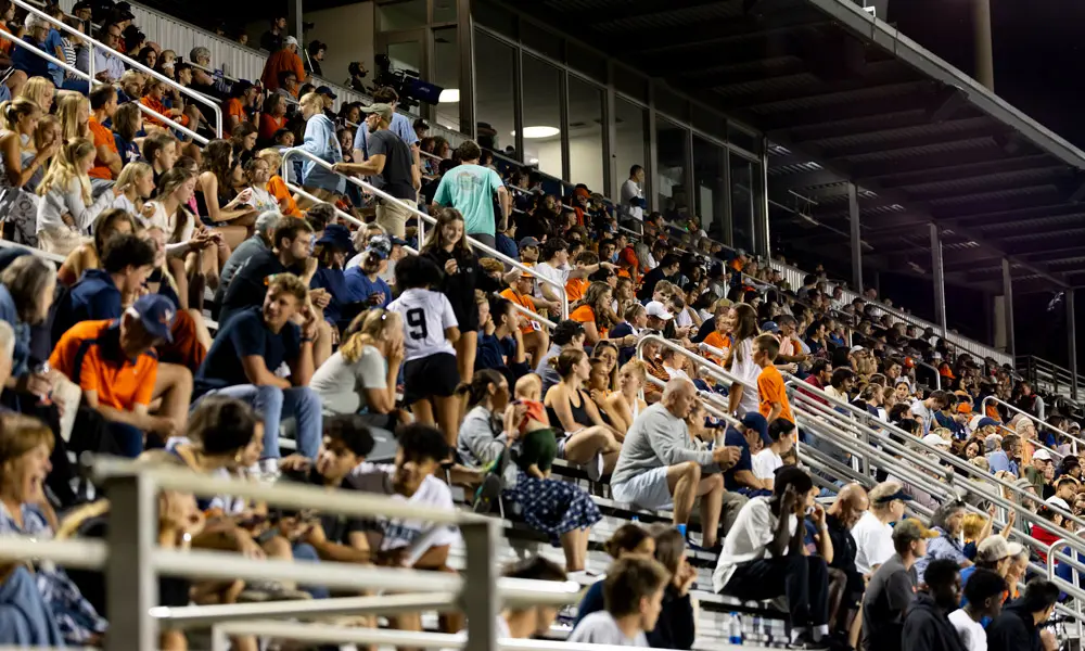 Fans cheering at a women's soccer game